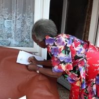 Elderly lady signing to acknowledge receipt of her parcel from OBADO
