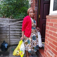Eldery lady in Bury receiving her parcel of cultural foods and hoe essential items.