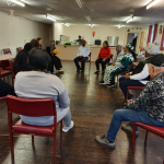 Students engaged older people in a group ball activity.
